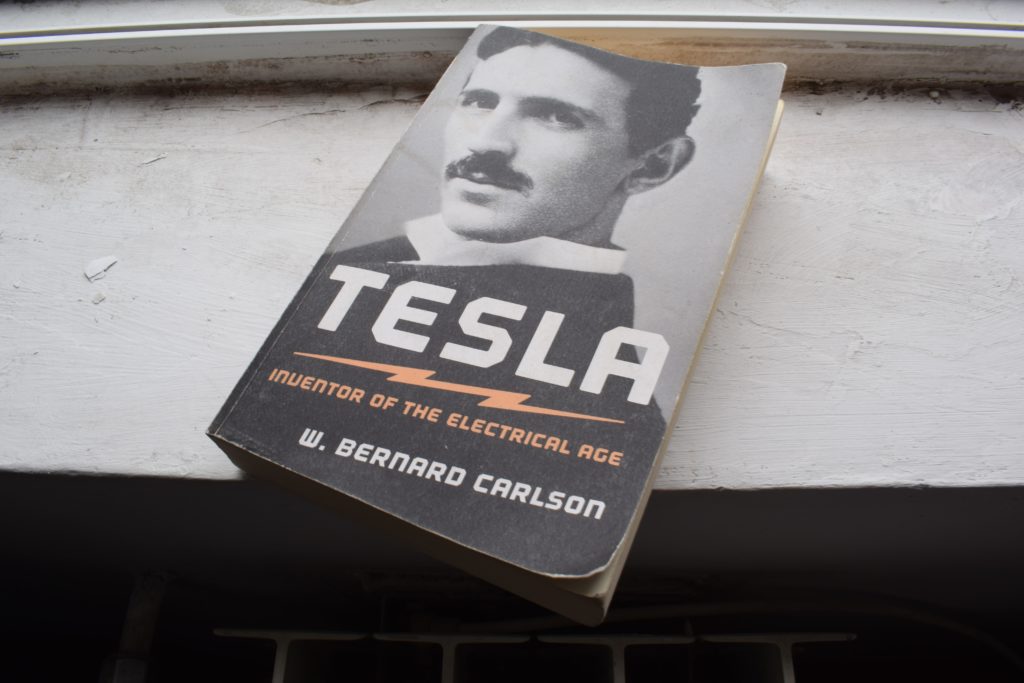 A book about Nikola Tesla next to a window